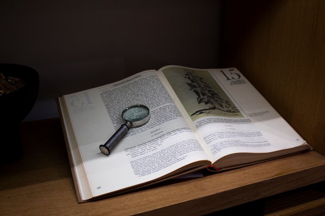 Open book with magnifying glass on top